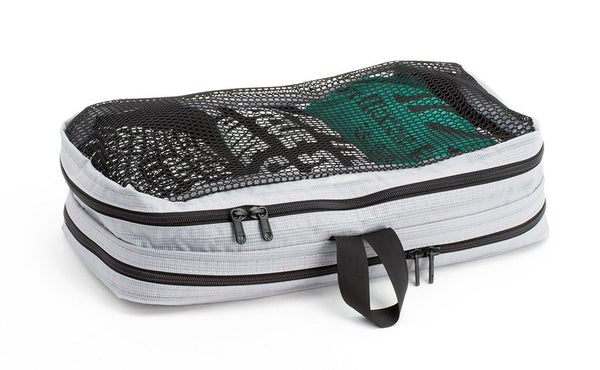 A filled and zipped closed Northwest Sky (light grey) Aether Small Laundry Aeronaut 30 Packing Cube showing the mesh side.